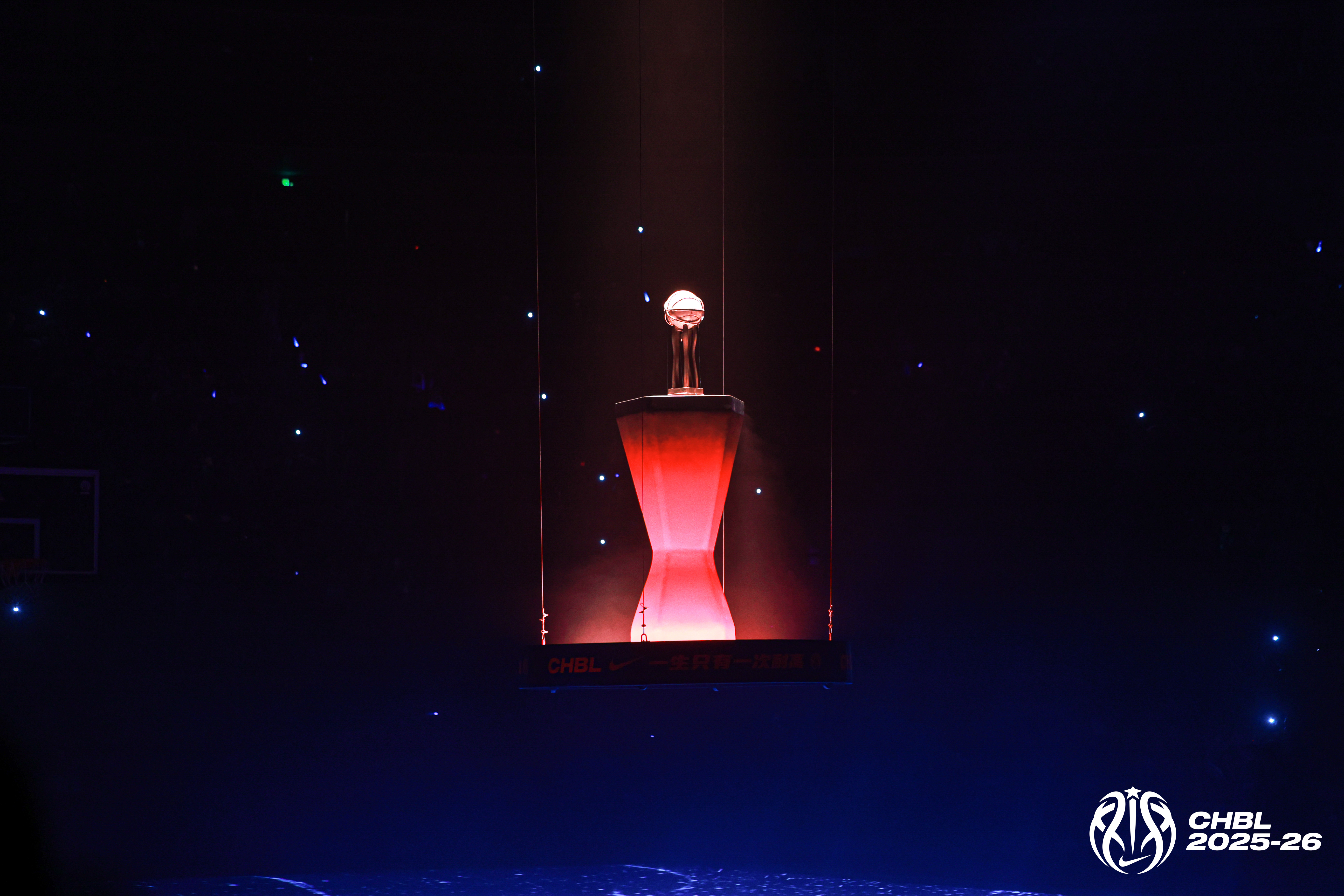 Basketball trophy lit dramatically in a dark arena